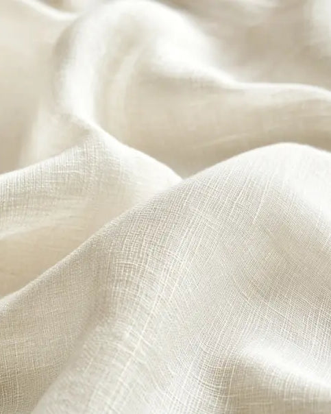 Close-up of beige linen fabric drapery sample, showing its soft texture and smooth folds.